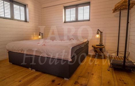 Slaapkamer in duurzaam huis met houten beplating als vloer