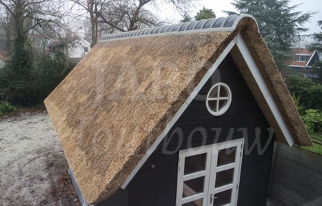 Gemetselde nokvorsten op rieten kap van bijgebouw in Bergen