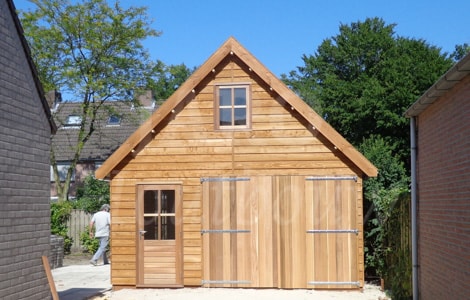 Bijgebouw van hout naast de woning