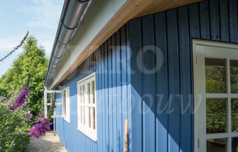 Chalet op maat uitgevoerd met blauwe gevelbekleding en een zinken goot