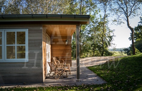 Chalet van hout met inpandige luifel en landelijk tuinset