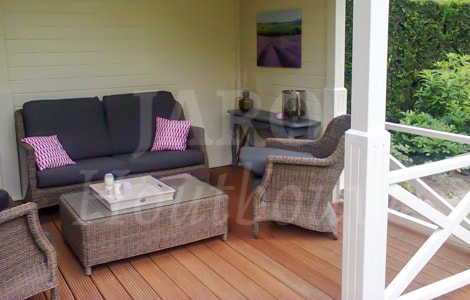 Veranda in de tuin met houten vlonder en tuinset