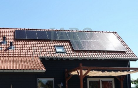 Een houten huis met zonnepanelen en dakpannen