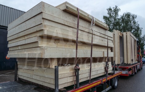 Vrachtwagen met prefab gevelwanden in houtskeletbouw