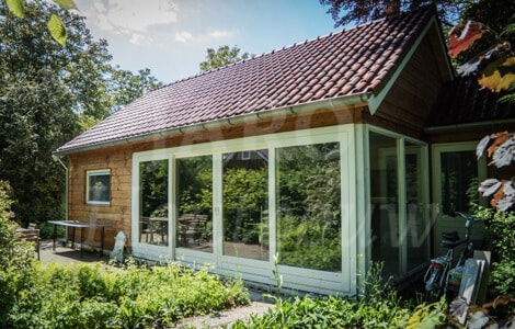 Landelijk houten chalet in bosrijke omgeving met genuanceerde dakpannen