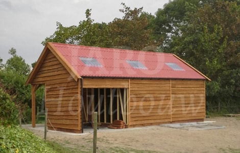 Paardenstal van hout in de tuin met golfplaten