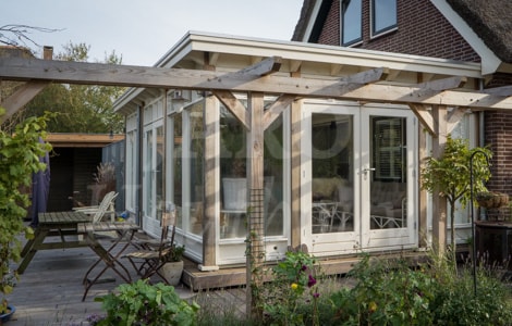 Houten veranda als tuinkamer aan de woning