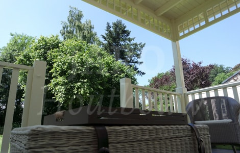Uitzicht over de tuin vanaf houten veranda aan woning