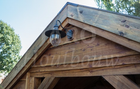 Detailfoto van lariks overkapping in de tuin met buitenlamp