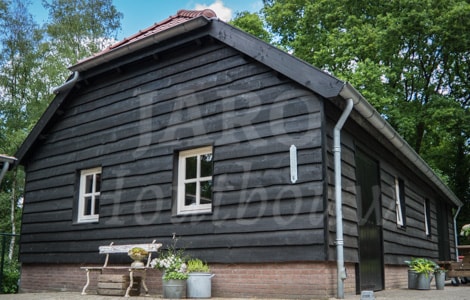 Geschilderde zwarte landelijke schuur van hout