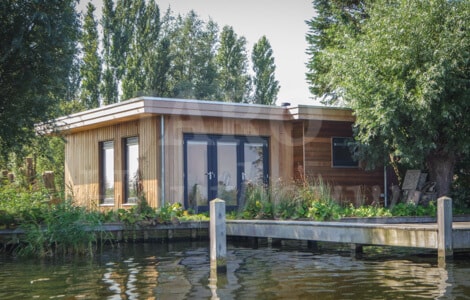 Een houten vlonder voor luxe chalet met tuinstoel