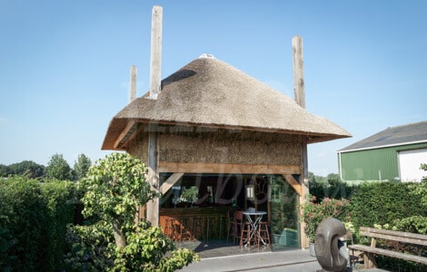 Houten hooimijt met rieten kap in de achtertuin