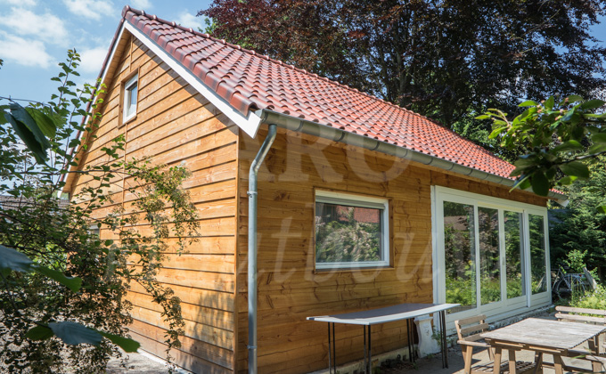 Gezellige inrichting van vakantieverblijf met een bank, twee stoelen en tafel